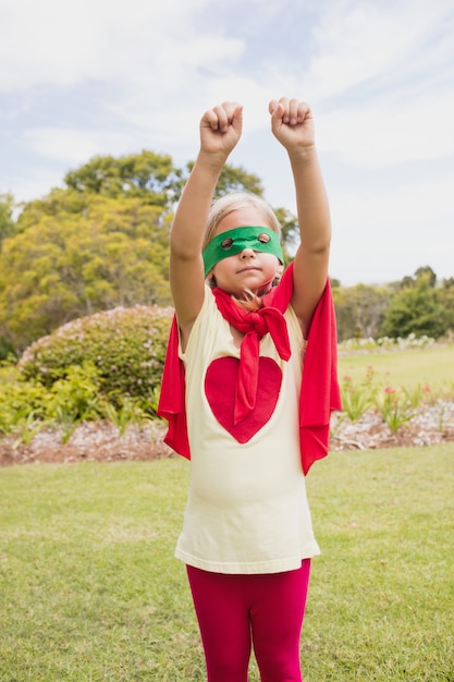 Niña fingiendo fingir volar con traje de superhéroe