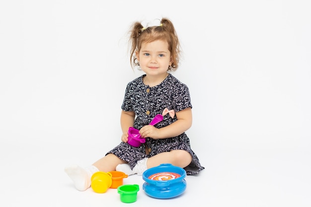 Niña fingir jugar la preparación de alimentos en el fondo blanco.