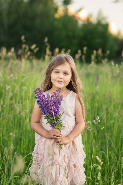 niña y flor de lupino en la naturaleza