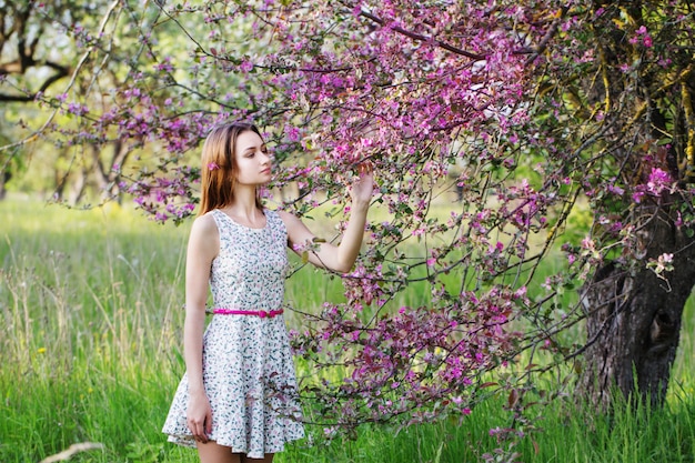 Niña con flores en el jardín de primavera