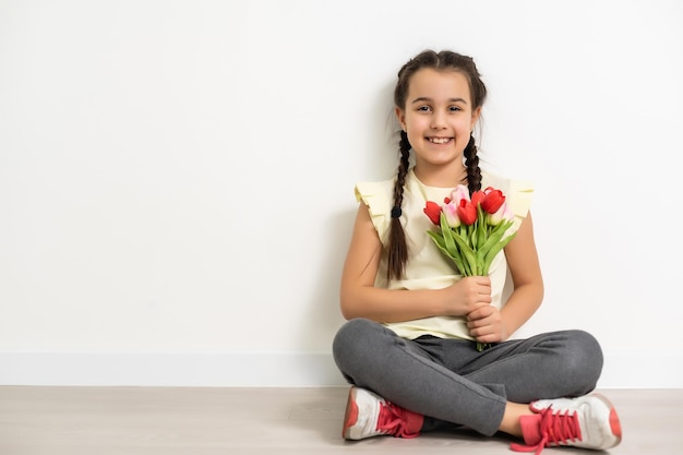 niña con flores sobre un fondo blanco.