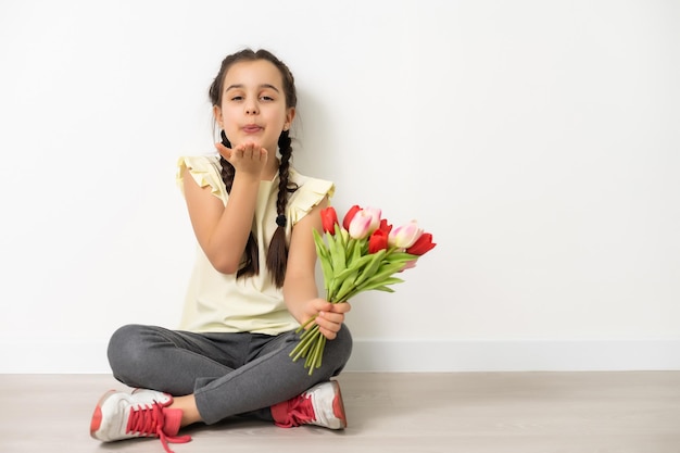 niña con flores sobre un fondo blanco.