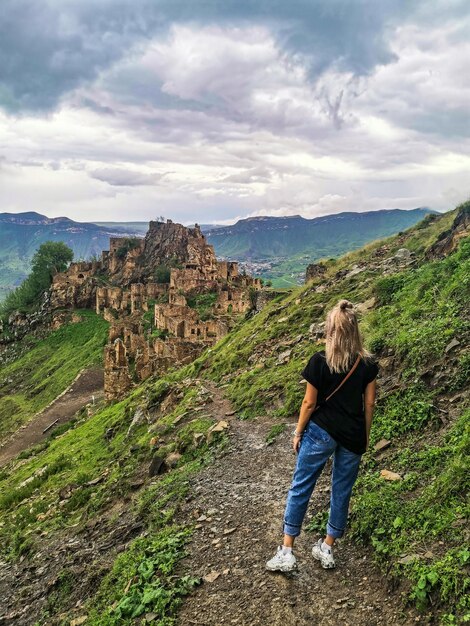 Una niña en el fondo de la aldea de Gamsutl en las montañas del Cáucaso en la cima de un acantilado Daguestán Rusia junio de 2021