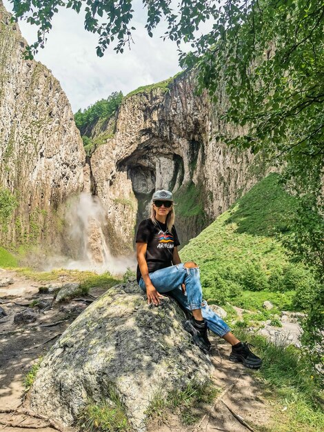 Una niña en el fondo de la cascada TuzlukShapa en el territorio de KabardinoBalkaria Cáucaso Rusia