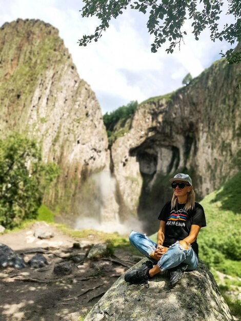 Una niña en el fondo de la cascada TuzlukShapa en el territorio de KabardinoBalkaria Cáucaso Rusia