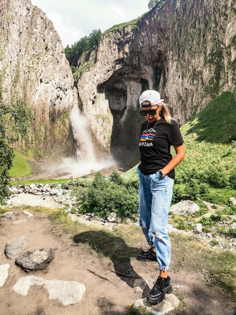 Una niña en el fondo de la cascada TuzlukShapa en el territorio de KabardinoBalkaria Cáucaso Rusia