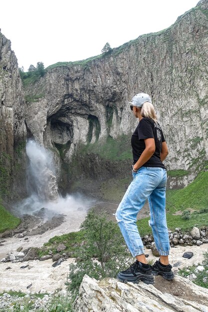 Una niña en el fondo de la cascada TuzlukShapa en el territorio de KabardinoBalkaria Caucasus