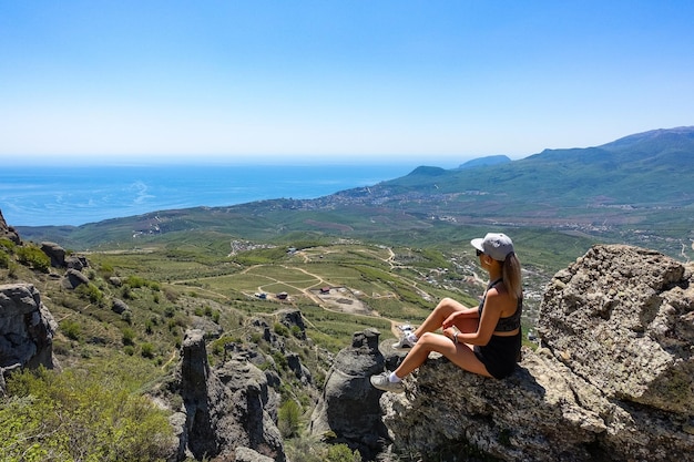 Una niña en el fondo de la meseta de las montañas de Crimea y el Mar Negro desde lo alto de Demerji Rusia