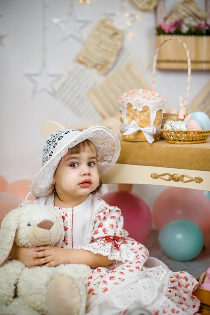 Una niña en un fondo de Pascua con pasteles y huevos.