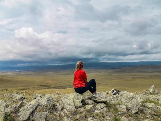 Una niña en el fondo de una vista pintoresca de las estepas de Tazheran, región de Irkutsk, Rusia, julio de 2020