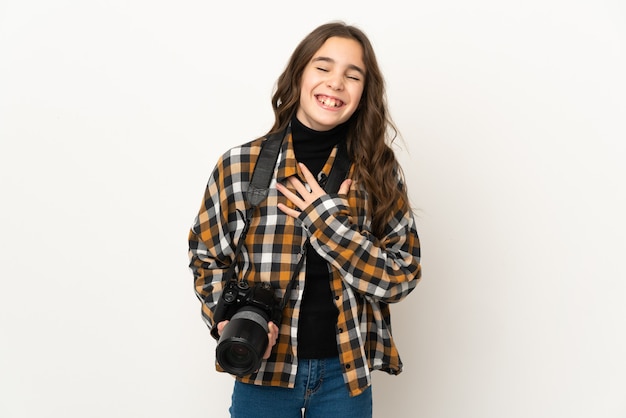 Niña fotógrafa aislada en la pared sonriendo mucho