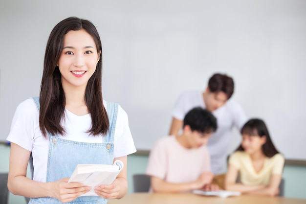 Una niña se para frente a un grupo de estudiantes en un salón de clases.