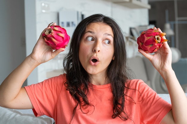 Niña y fruta del dragón. Chica alegre disfrutando de frutas tropicales.