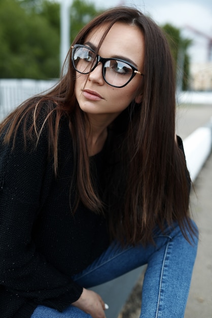 Niña con gafas caminando en verano en la ciudad