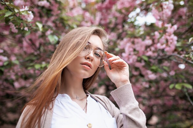 Niña con gafas cerca del cerezo