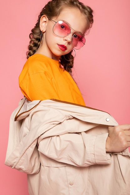 Niña en gafas de color rosa Estilo de moda de moda concepto de tiempo de diversión con estilo Retrato de cuerpo entero de tamaño completo vertical de risa linda dulce adorable encantadora encantadora niña aislada fondo rosa