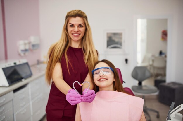 Niña con gafas protectoras visitando al dentista en la clínica Concepción de estomatología