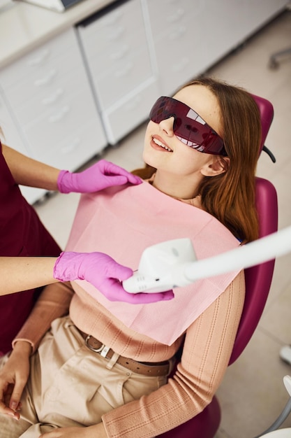 Niña con gafas protectoras visitando al dentista en la clínica Concepción de estomatología