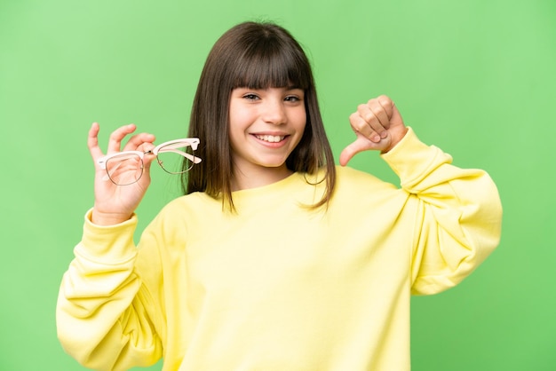 Niña con gafas sobre fondo clave de croma aislado orgullosa y satisfecha