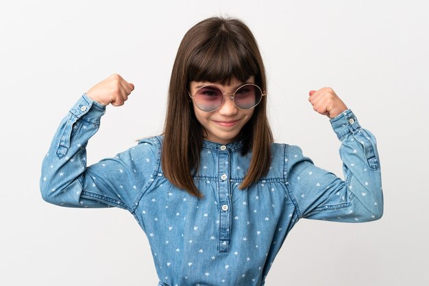 Niña con gafas de sol aislado sobre fondo blanco haciendo gesto fuerte