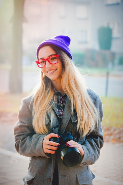 Niña con gafas y sombrero con cámara