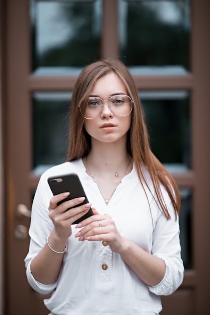 Niña con gafas con teléfono