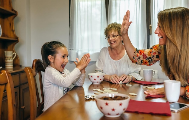 Niña ganando dominó su madre y su abuela