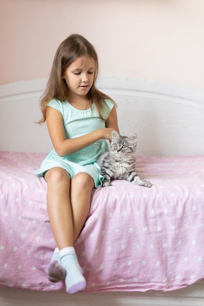 Foto niña con gatito en la habitación