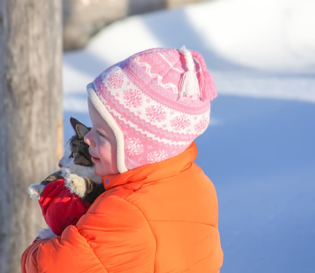 Niña con gato al aire libre en invierno