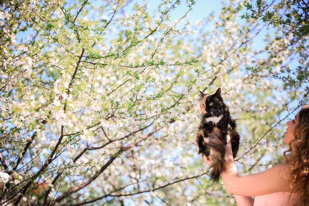 Niña y gato. Concepto de clima cálido de primavera o verano. Bokeh de fondo.