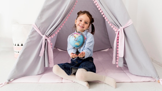 Foto niña con globo posando en carpa