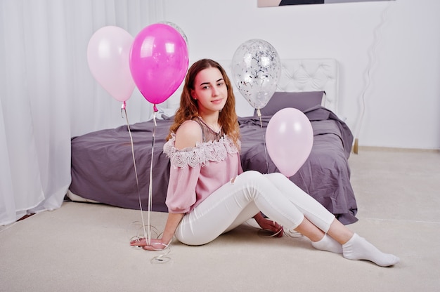 Niña con globos en la cama posó