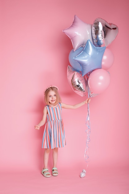 Niña con globos y vestido de rayas