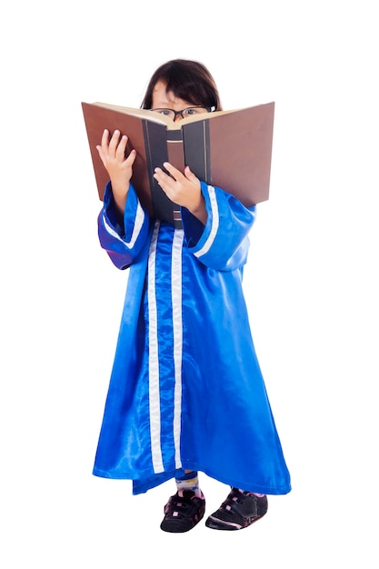 Niña graduada leyendo un libro en el estudio