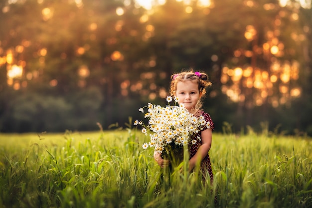 Niña con un gran ramo de flores de margaritas