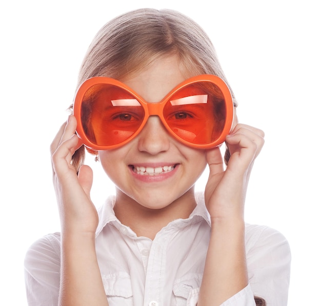 Niña con grandes gafas naranjas aislado en el concepto de estilo de vida y personas de fondo blanco