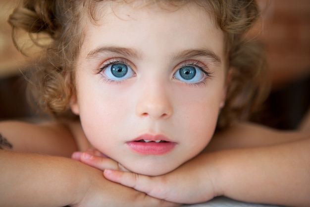 Foto niña de grandes ojos azules mirando a la cámara