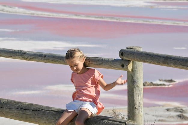 Una niña en la granja de sal SalindeGiraud con agua salada rosa