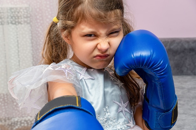 Niña con guantes de boxeo azules y un vestido de fiesta con estrellas