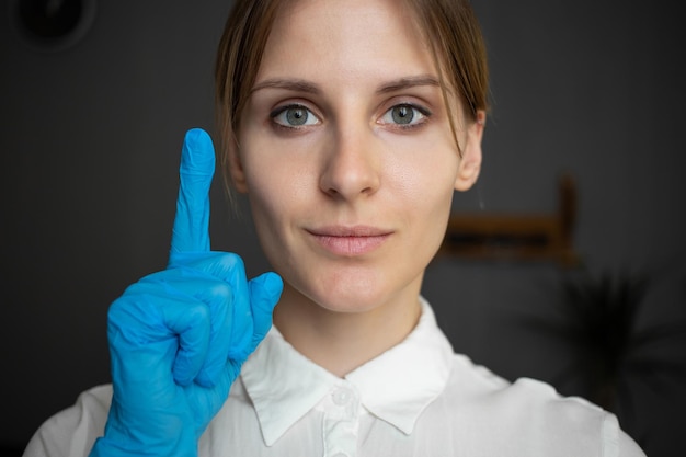 Niña con guantes médicos azules muestra su dedo