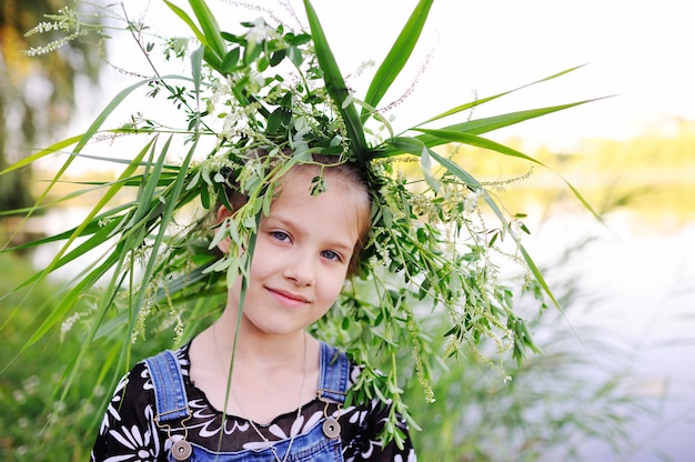 Niña en una guirnalda de flores silvestres