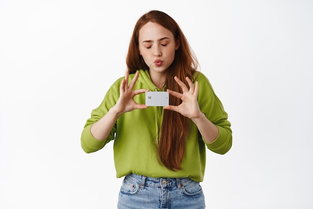 A la niña le gusta ir de compras, besar su tarjeta de crédito con los ojos cerrados, comprar algo, pagar la compra, hacer un pedido en línea en blanco.