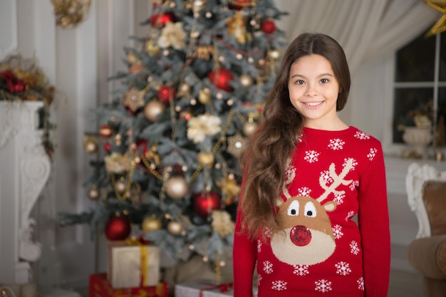 A la niña le gusta el presente de Navidad. Feliz Año Nuevo. pequeña niña feliz en navidad. Navidad. Niño disfruta de las vacaciones. La mañana antes de Navidad. Vacaciones de año nuevo. Feliz navidad y próspero año nuevo.