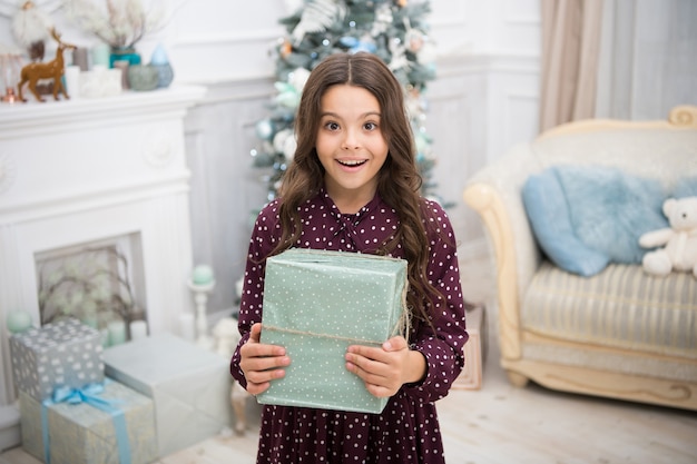 A la niña le gusta el presente de Navidad. Feliz Año Nuevo. pequeña niña feliz en navidad. Navidad. Niño disfruta de las vacaciones. La mañana antes de Navidad. Vacaciones de año nuevo. Gracias. Querido Santa.