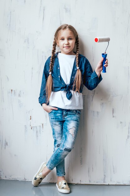 Niña en una habitación con una pared de madera. Construcción