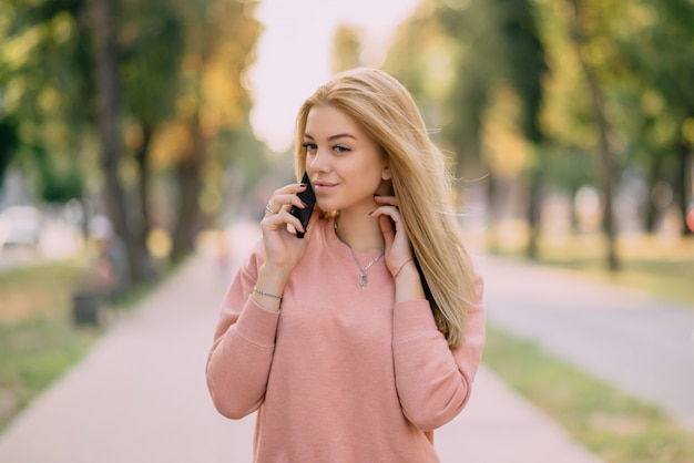 Niña habla por teléfono al aire libre