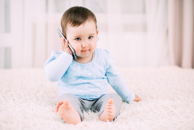 Una niña hablando por un teléfono inteligente sonriendo y feliz