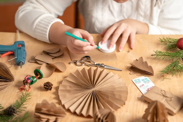 niña hace adornos para árboles de Navidad con papel con sus propias manos