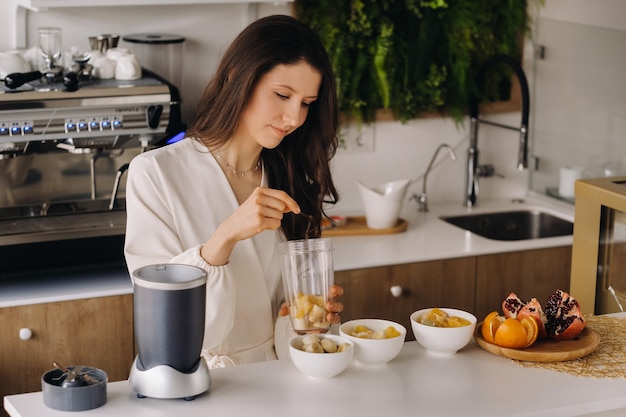 Una niña hace un cóctel de desintoxicación de frutas en la cocina Dieta para bajar de peso