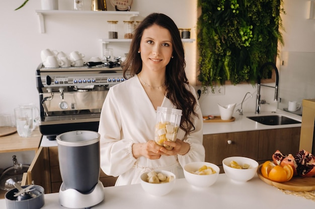 Una niña hace un cóctel de desintoxicación de frutas en la cocina Dieta para bajar de peso